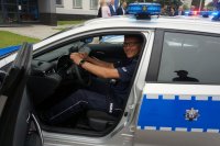 policjant siedzi za kierownicą radiowozu