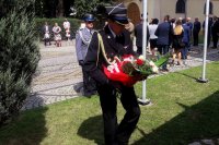 komendant policji i straży pożarnej składają kwiaty pod pomnikiem