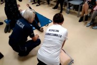 policjantka pokazuje kobiecie jak wykonać masaż serca na fantomie