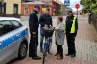 policjanci wraz z pracownikiem UG w Miedźnie wręczają rowerzyście odblaski i lampki rowerowe