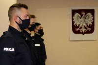 umundurowani policjanci, w tle godło Polski