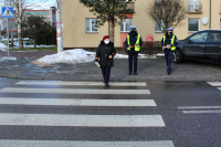 dwoje policjantów ruchu drogowego obserwuje pieszą przechodząca przez pasy