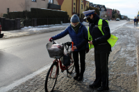 policjantka ruchu drogowego zakłada odblask rowerzystce