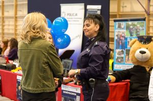 Zdjęcie przedstawia policjantkę rozmawiającą z uczestnikami dnia otwartego.