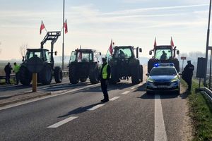 Zdjęcie przedstawia policjantów, radiowóz oraz ciągniki rolnicze.